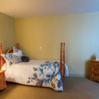 A cozy bedroom with a wooden bed and nightstand.