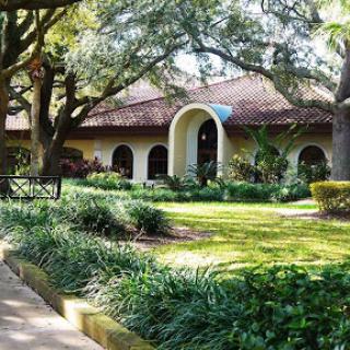 A charming architectural structure surrounded by lush greenery and a well-maintained garden.