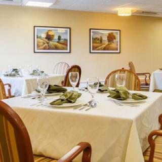 A beautifully arranged dining area featuring elegant table settings and tasteful artwork on the walls.