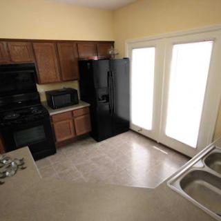 A modern kitchen featuring black appliances and plenty of natural light.