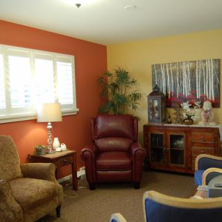 A cozy living room with armchairs and warm decor.