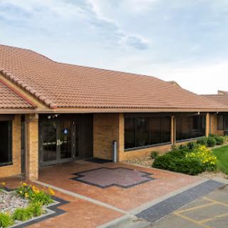 A modern residential building with a tiled roof and landscaped entrance.