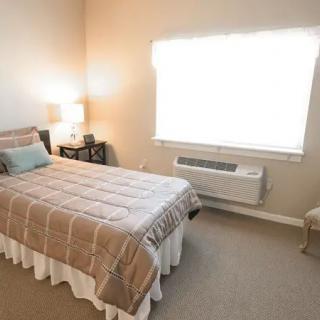 A cozy bedroom with a single bed and soft lighting from lamps.