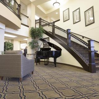 Elegant lobby with a grand staircase and piano.