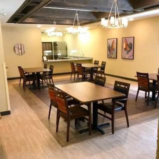 An empty restaurant dining area with neatly arranged tables and chairs.