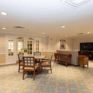 A well-lit room featuring a table with chairs and a sofa, arranged for a comfortable gathering space.
