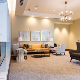 A modern living room featuring comfortable seating, elegant lighting, and tasteful artwork.