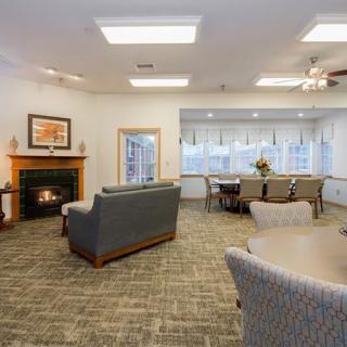 A modern living and dining area featuring a cozy fireplace, comfortable seating, and a well-lit dining table.