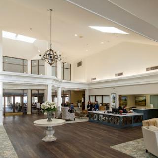 A spacious and elegantly designed interior lobby featuring a chandelier and modern furnishings.