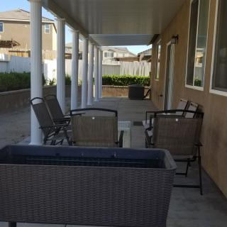 A spacious patio area with outdoor furniture and white columns.