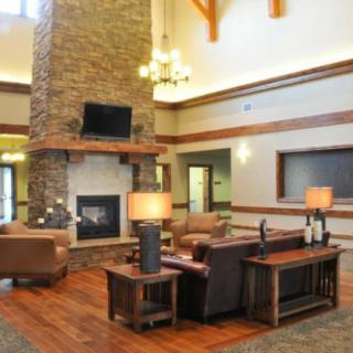 A rustic-style living room with a stone fireplace and comfortable seating.