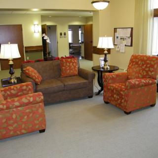 A cozy living room with a sofa, armchairs, and decorative lamps.