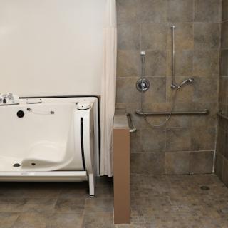 An accessible bathroom featuring a walk-in bathtub and a barrier-free shower area.