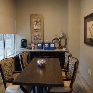 A cozy dining area with a wooden table, upholstered chairs, and decorative wall art.