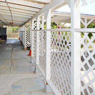 A white lattice carport structure providing shade and shelter.