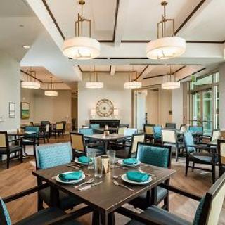 An elegant and modern restaurant dining area with stylish chandeliers and a neatly arranged table setting.