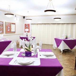 An elegant dining area with purple tablecloths and neatly arranged table settings.