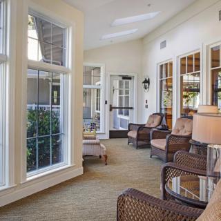 A cozy sunroom with wicker chairs and large windows allowing natural light to flood the space.