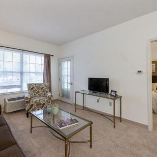 A cozy living room with a TV, coffee table, and comfortable seating.