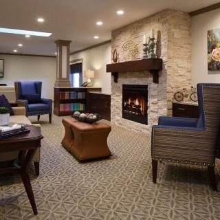 A cozy living room featuring a stone fireplace, comfortable seating, and elegant decor.
