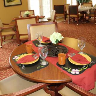 Elegant dining table set with red and black themed decor in a formal restaurant setting.
