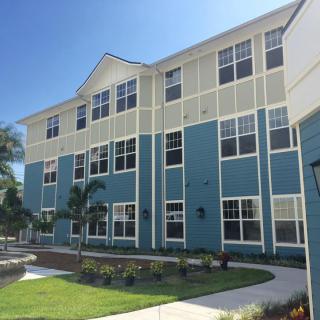 A modern apartment building with blue and beige exterior under a clear sky.