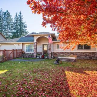 A charming house with a yard covered in colorful autumn leaves.