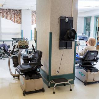 A rehabilitation facility with exercise equipment and a person using a machine.