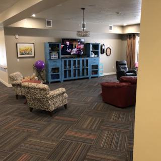 A cozy living room featuring comfortable seating, a television, and a decorative blue cabinet.