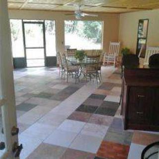 Spacious living and dining area with tiled flooring and large windows.