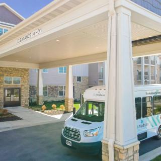 A building entrance with an adjacent van parked outside.