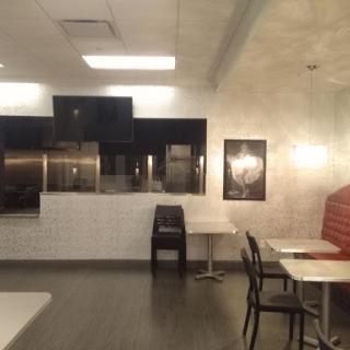 A modern dining area in a restaurant, featuring tables and chairs with soft lighting.