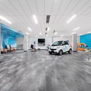 A modern office space featuring an open floor plan with a small car parked indoors.