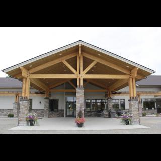 A modern architectural entrance featuring a wooden canopy and stone accents.