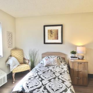 Cozy bedroom with a single bed, decorative elements, and warm lighting.