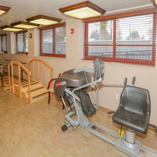 A rehabilitation gym featuring exercise equipment and a set of stairs.