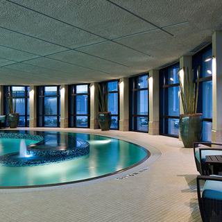 A luxurious indoor pool with modern design and large windows allowing ample natural light.