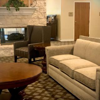 A cozy living room featuring a comfortable sofa, armchair, coffee table, and a fireplace.