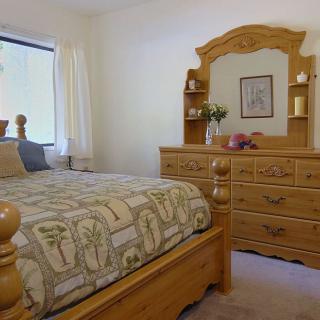 Cozy bedroom with wooden furniture and a large window.