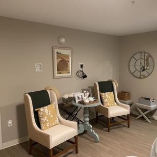 A cozy living room with two chairs, decorative pillows, and modern wall art.