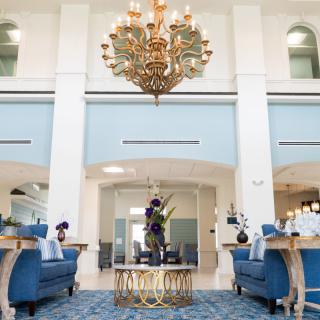 A luxurious lobby with elegant blue furniture and a grand chandelier.