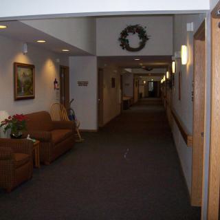 A decorated hallway with seating and wall art.