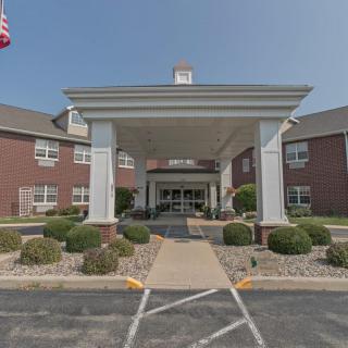 A building entrance with a covered driveway and landscaped pathway.