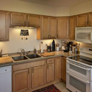 A cozy kitchen with wooden cabinets and modern appliances.