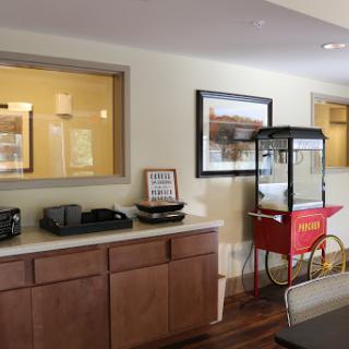 A cozy interior featuring a snack bar with a popcorn machine and wooden cabinets.