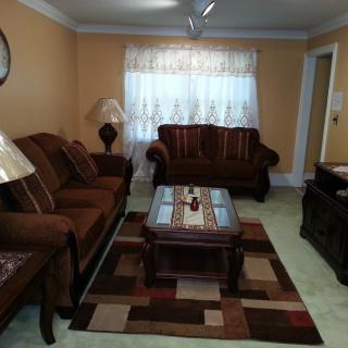 A cozy living room with a brown sofa set, coffee table, and decorative rug.