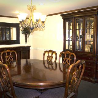 A classic dining room with elegant wooden furniture and a chandelier.
