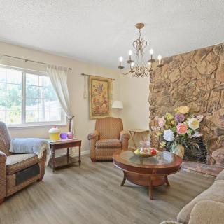 A cozy living room with comfortable furniture, a chandelier, and decorative elements.