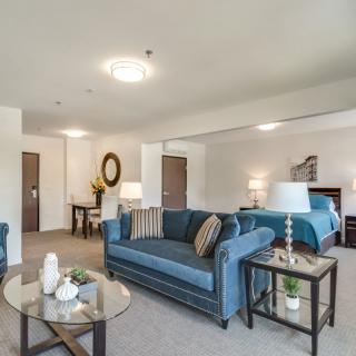 A modern living room interior with blue sofas, a glass coffee table, and stylish decor.