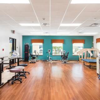 A spacious rehabilitation center equipped with various physical therapy equipment and facilities.